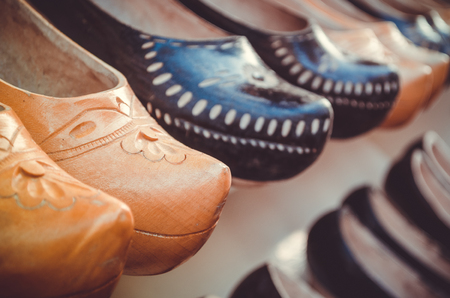 typical spanish handcrafted wooden shoes called zuecos form two lines in shop standの写真素材