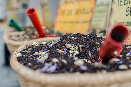Red and green shovels inside differente mixtures of teas in a jumble sale in Sevilla, Spainの写真素材