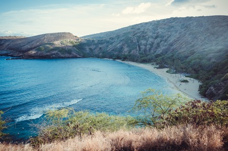 Big hills surround this little sand beach full of people in Hawaii, USの写真素材