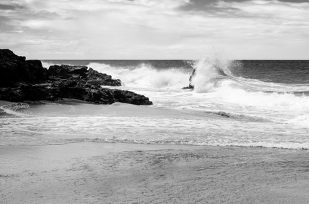 Strong black and white image of the waves beating against the rocks in a Kauai beach, USの写真素材