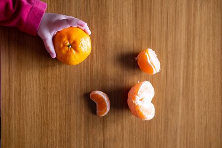 Baby s hand manipulating different fruits on a wooden tableの写真素材