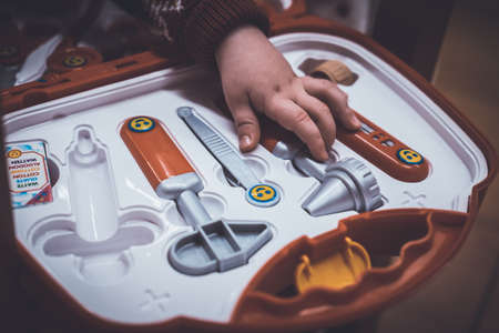 Kids hands on a toy medical briefcase