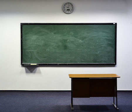 Empty classroom presenting a blackboard, dashboard in obscure light creating shadowsの写真素材