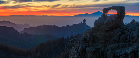 spectacular sunset over roque nublo mountain on Gran Canaria, in the background visible volcano Teide on tenerifeの写真素材