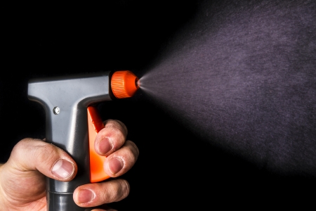 water sprayer being used on black backgroundの写真素材
