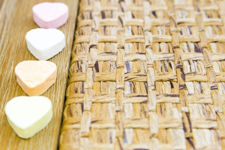 four candy hearts on a wooden backgroundの写真素材