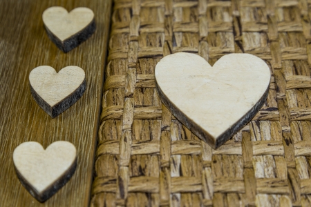 three small and one big wooden heartの写真素材