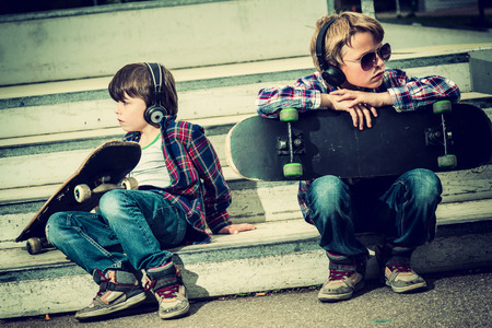 two cool skaters resting on stairsの写真素材