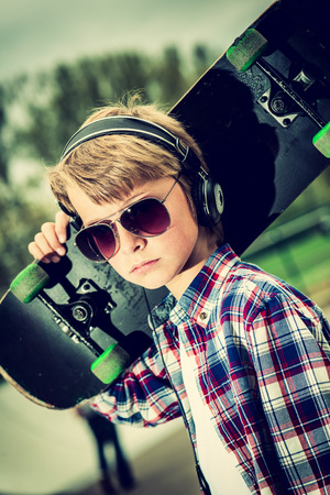 cool looking skater boy, with sunglasses and headphoneの写真素材