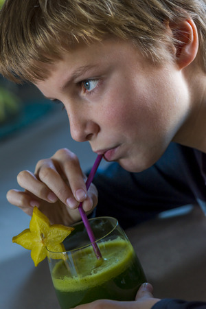 boy with a glass of healthy green juiceの写真素材