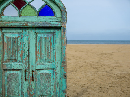old wooden door leading to a beautiful beachの写真素材