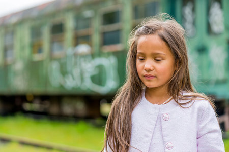 llittle thai girl in front of train carriage. shallow depth of field. this image looks great in black & white, or sepia.の写真素材