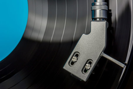 top view of a headshell from a record player while playing record, close up