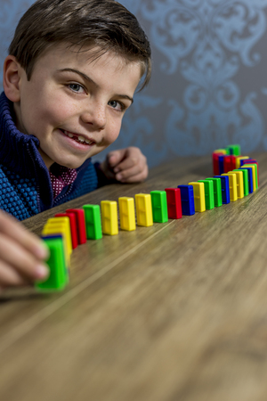 boy placing domino pieces on a table, shallow depth of fieldの写真素材