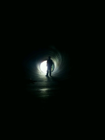 Construction worker standing in a big pipeの素材
