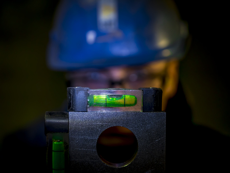 construction worker checking spirit level or bubble level in a dark placeの写真素材