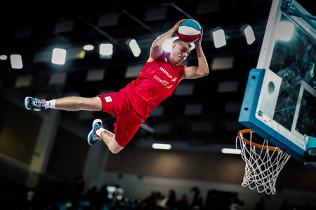 Tenerife, Spain, September 22, 2018: basketball player jumps over the basket with ball in hands...