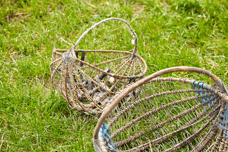 Two empty old wicker baskets on green grassの写真素材