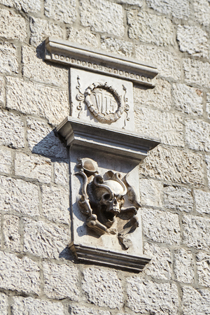 stone relief on the wall with the image of a skull, a turtle, a snake, a rat and bones. Medical symbolの写真素材