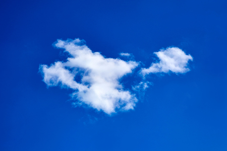 lonely white fluffy cloud on blue sky backgroundの写真素材