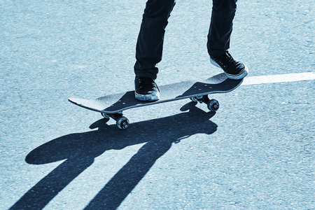 Shadow of a skateboarder on asphalt. Blue toningの写真素材