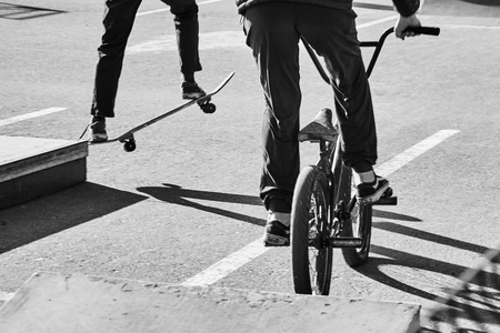 Skateboarder and bicycler. Black and white imageの写真素材