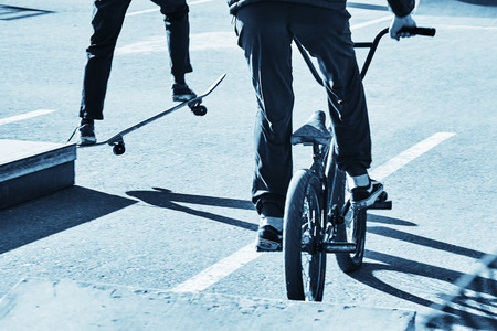 Skateboarder and bicycler. Blue toningの写真素材