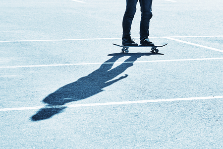 Shadow of a skateboarder on asphalt. Blue toningの写真素材
