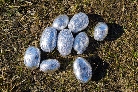 potatoes in foil on dry grassの写真素材