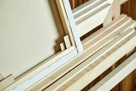 Primed art cotton canvas stretched on a wooden modular stretcher with wedges. Back view. Selective focusの写真素材