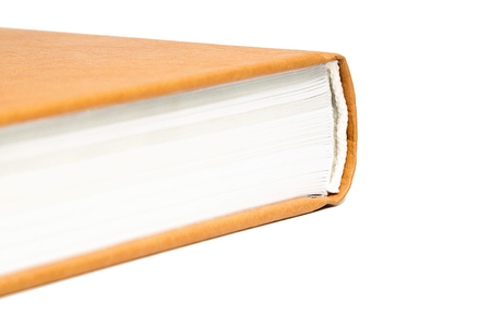 The book is in a bright brown hard leather cover. Isolated on white background. Closeupの写真素材