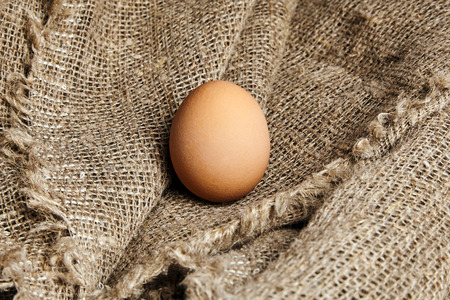 brown and speckled fresh chicken egg in on Sackcloth texture background . Closeupの写真素材
