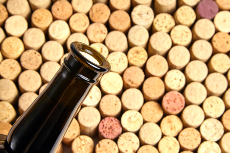 corked glass bottle of red wine, side view. Background pattern of used bottles corksの写真素材