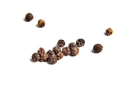 Black peppercorns on white background isolated