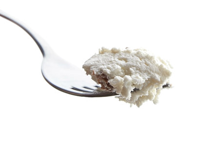 cottage cheese with raisins and steel shiny fork. Isolated on white background