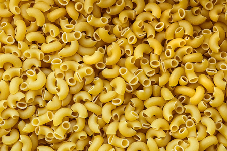 Uncooked italian pasta background. Elbow Macaroni with a smooth surfaceの写真素材