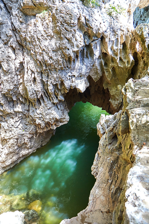Cave in rock filled with river water. Glare on the stone surface of the mainsail. reflection of liquid on the wall of grottoの写真素材