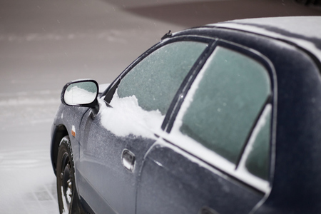 Snow on car after snowfall. Winter in european cityの写真素材