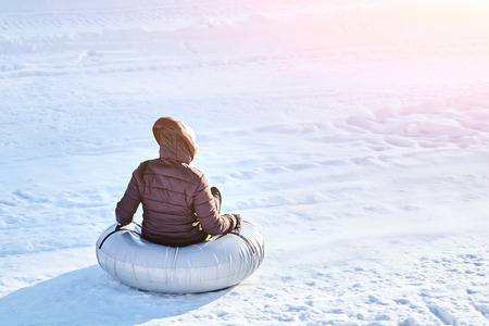 woman or little girl is sliding fast downhill on an inner tube. back viewの写真素材