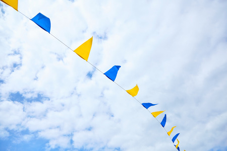 Multicolored triangular festival flags on blue sky background. Outdoor Celebration Party. Festive moodの写真素材
