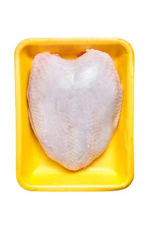 Raw chicken breast with skin in a yellow plastic container. Meat of poultry in tray, isolated on white background. Nobody. Top viewの写真素材