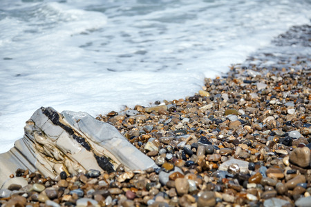 Rocky coast of the Atlantic Ocean. Sea waves and pebble beach. Wet gray stones on the shoreの写真素材