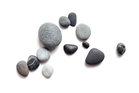 Scattered sea pebbles. Smooth gray and black stones isolated on white background. Top viewの写真素材