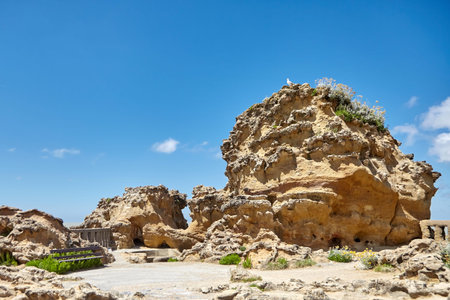Weathered sandstone. Bench and stones  on blue sky backgroundの写真素材