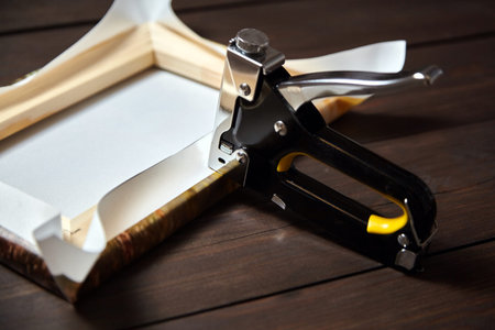 Canvas stretching on wood stretcher bar. Photo printed on canvas (back view) and stapler on brown...