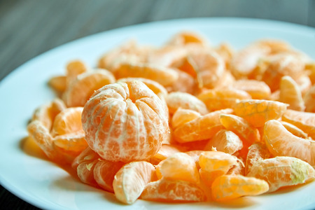 Peeled segments of tangerine on plate. Mandarin citrus fruitの写真素材