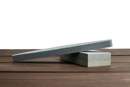 Two grindstones. Oval and rectangular double layer sharpening stone. Whetstone sharpener on wooden table backgroundの写真素材
