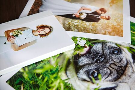 Photo canvas prints. Sample of stretched photography of woman with gallery wrap. Printed photos of a dog and a wedding couple lying on a tableの写真素材