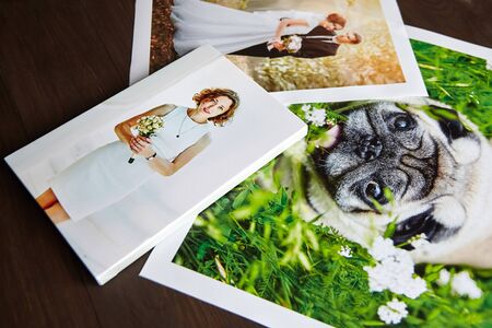 Photo canvas prints. Sample of stretched photography of woman with gallery wrap. Printed photos of a dog and a wedding couple lying on a tableの写真素材