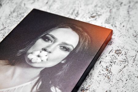 Gallery wrap, photo printed on glossy synthetic canvas and stretched on wooden stretcher bar, lateral side closeup. Selective focusの写真素材